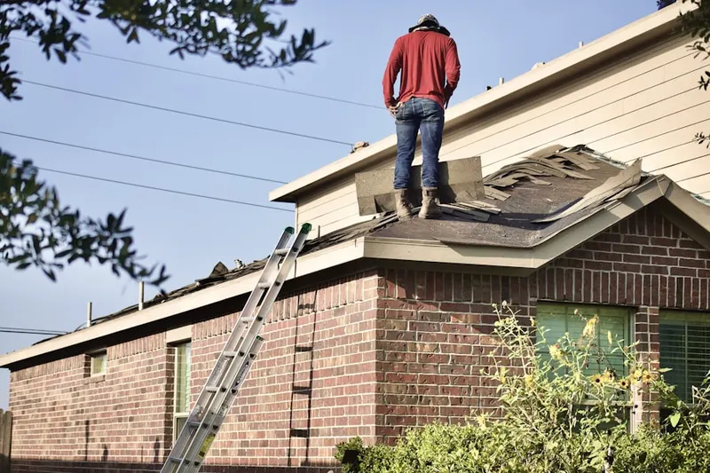 Professional roofer working on a residential roof in Wooddale Farms